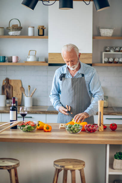 istock Happy retired senior man cooking in kitchen 2183948816