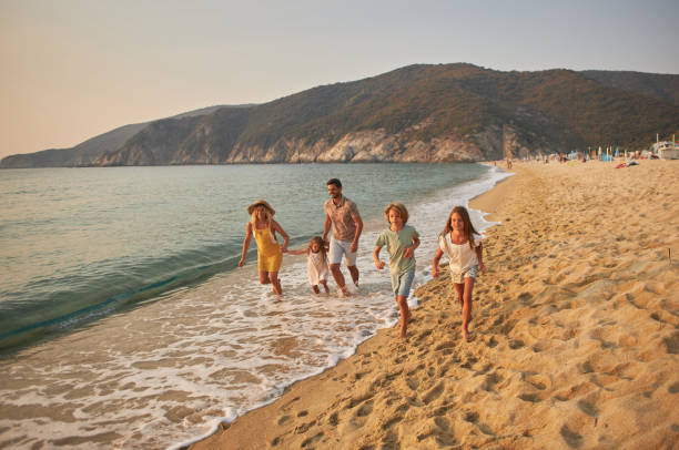 istock A family run hand in hand down a tropical paradise beach during sunset 2183950939