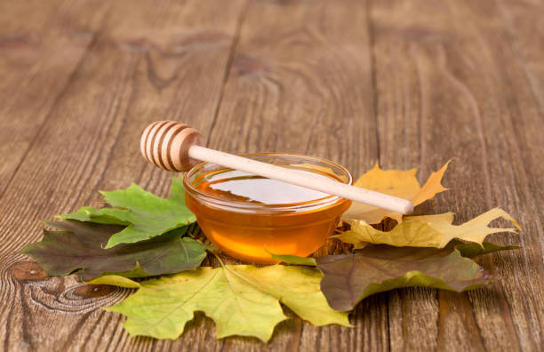 istock Honey and leaves on a wooden table 2183954776
