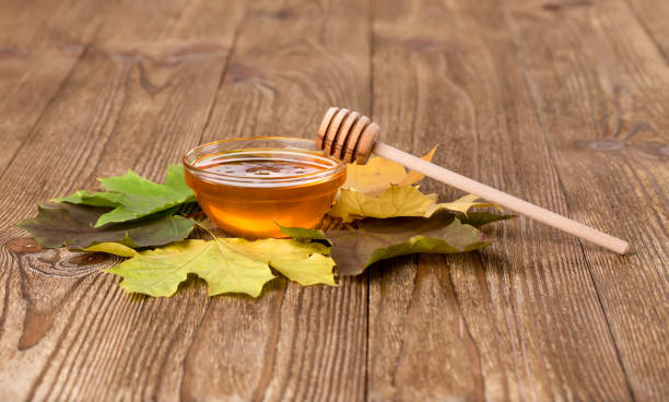 istock Honey and leaves on a wooden table 2183954781