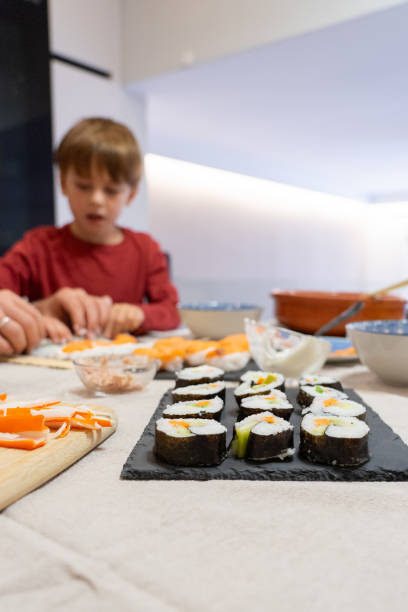 istock Boy learning to cook sushi in the kitchen at home 2183954877