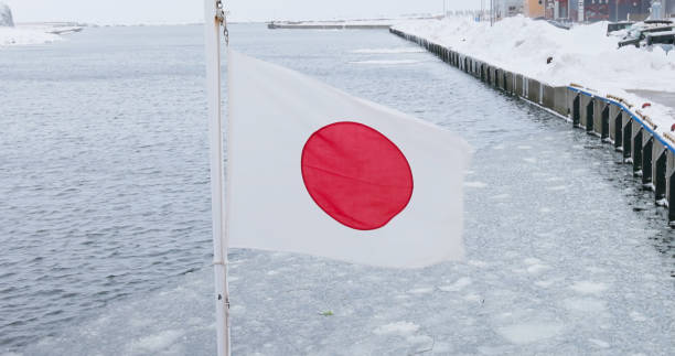 japanese flag waving on a ship in hokkaido icebreaker sailing through drift ice floes on the sea during winter