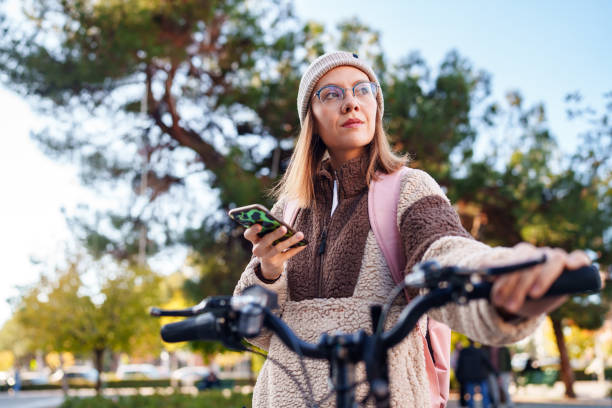 istock Woman with bicycle, using mobile phone in street 2183959764