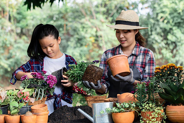 istock Mother teaching flower plants to daughter with happy, cute elementary kid learning how to plants flowers garden from mom, motherhood activity with child at home, owner girl spent time with cute child 2183961240