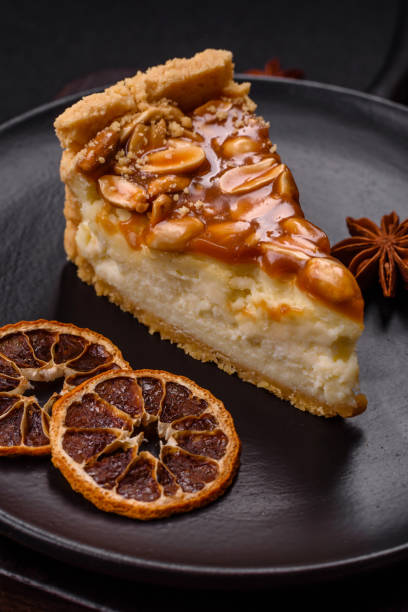 istock Delicious fresh cheesecake caramel peanut cake with cream and nuts on a ceramic plate on a dark concrete background 2183961400