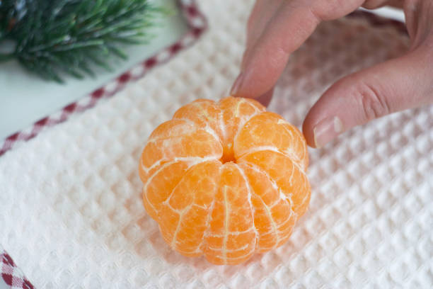 A peeled tangerine lies on a kitchen glove on the table