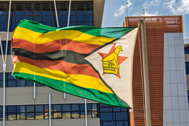 istock Zimbabwe country national flag on the pole, blue sky with clouds 2183967108