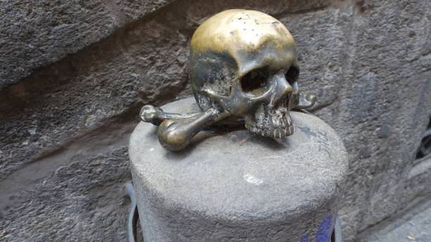 istock A lucky metal skull with crossbones on a stone. 2183967610