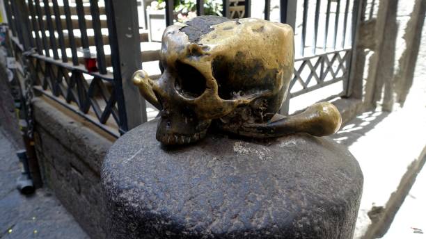 A lucky metal skull with crossbones on a stone in the old town center.