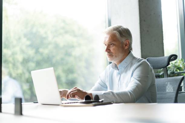 istock Mature 40s focused businessman, executive director working using laptop sitting at office 2183968935