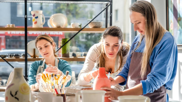 istock In an art studio with an environment adorned with artistic paintings in the background, three beautiful middle-aged women friends are happily drawing patterns and painting the vases they made from clay at a table filled with art supplies 2183971731