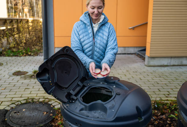 istock woman throws metal cap garbage into recycling bin outside 2183976281