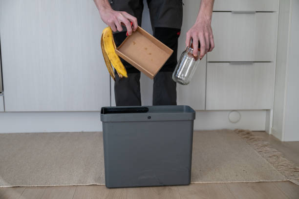 istock man's hands throwing out cardboard, glass, plastic and bio garbage into one bin. Throw different types of garbage into different recycling bins 2183977018