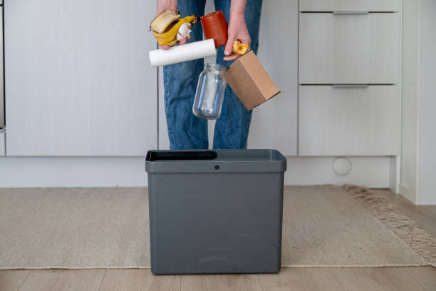 istock woman hands throwing out cardboard, glass, plastic and bio garbage into one bin. Throw different types of garbage into different recycling bins 2183977026