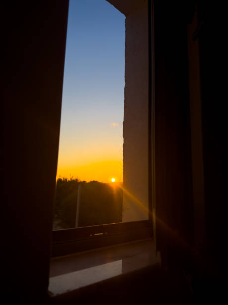 istock Golden Sunset Viewed From a Window, Casting Warm Light Into a Room at Dusk in a Peaceful Neighborhood Setting 2183979694