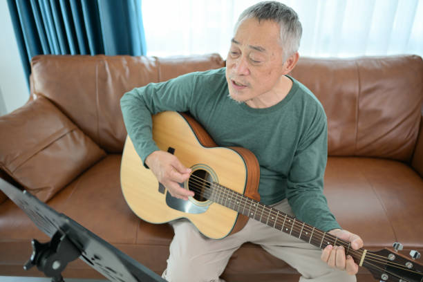 istock Senior man plays music at home 2183983117