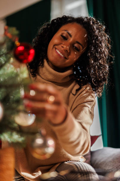 istock Happy woman decorating a small Christmas tree 2183986063