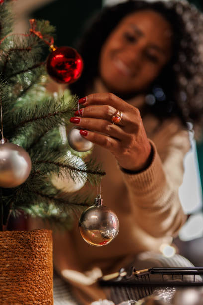 istock Happy woman decorating a small Christmas tree 2183986068