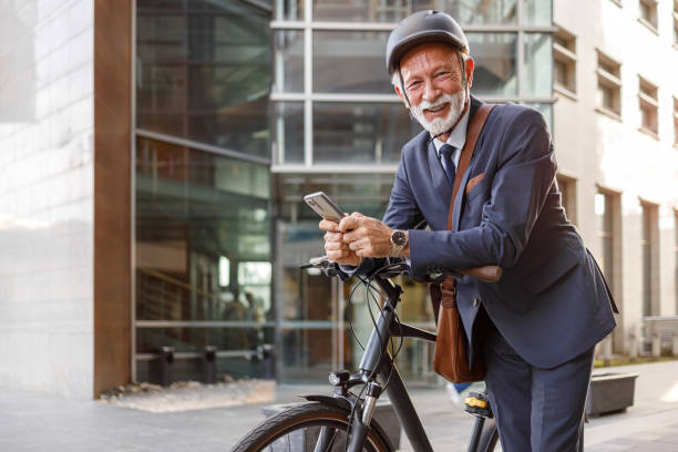 istock Portrait of senior male commuter using online apps over mobile phone while leaning on bicycle in city 2183988493