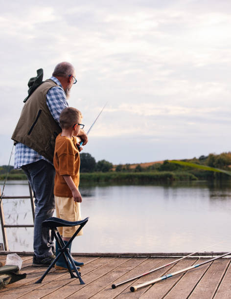 istock Grandfather and Grandson Bonding While Fishing at Lakeside 2183990728