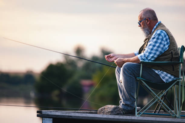 istock Elderly Man Relaxing While Fishing by a Serene Lake 2183990780