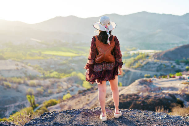 istock rear view standing latin woman looking at view outdoors a valley in the background 2183995099