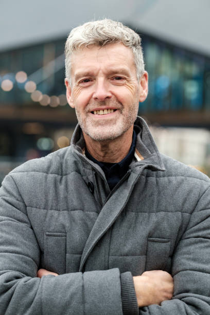 istock Smiling senior man with folded arms posing outdoors in the city 2183998477