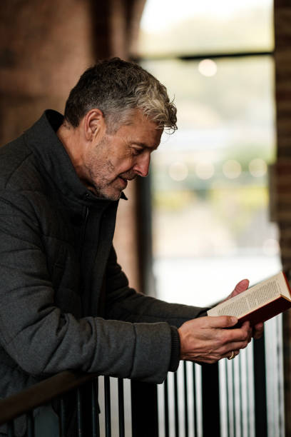 istock Mature man reading a book in a corridor 2183998482