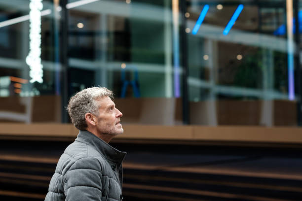 istock Mature man looking up at modern office building exterior 2183998490