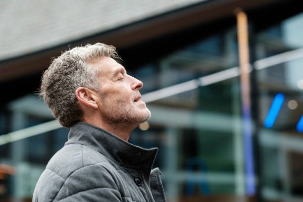 Businessman breathing fresh air outside office building