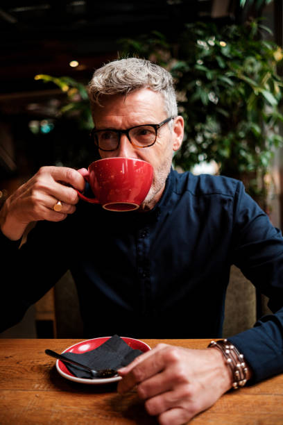 istock Stylish mature businessman drinking coffee in a modern cafe 2183998501