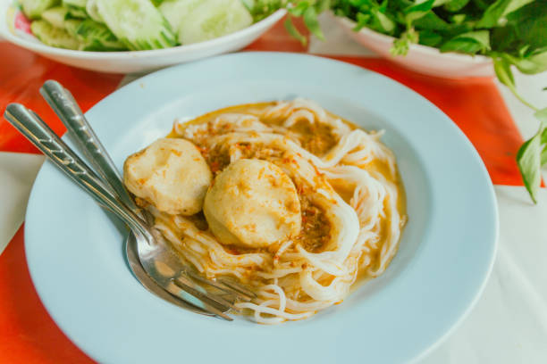 Thai Rice Noodles in Fish Curry Sauce with ingredient on table.