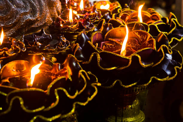 Close-up of  lotus shaped candles below Rahu statue in front of  Ganesha shrine  in Bangkok