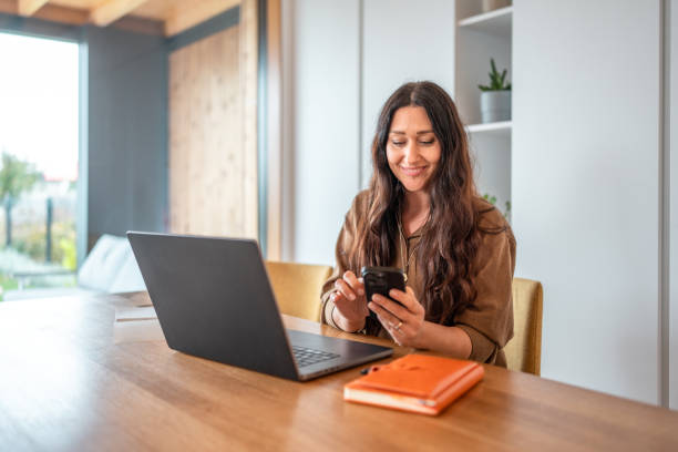 istock Professional Woman Multitasking with Technology in Home Office 2184003176
