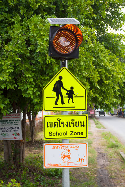 Caution school children crossing road sign in street opposite to school in Ayutthaya