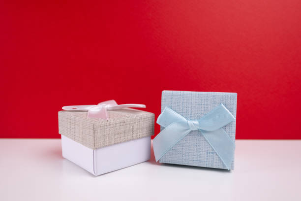 Stylish gift boxes with bow on color background. Valentines day gift for him. Corporate gift concept or birthday. Christmas background