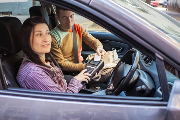 istock Contactless payment inside vehicle. Customer using a credit card to make an easy payment for services to the taxi driver after arriving to destination. 2184009135