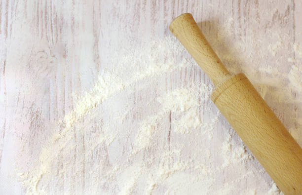 istock Background for baking with space for text. Rolling pin and flour on a white wooden surface. Top view with empty area for text. 2184009343