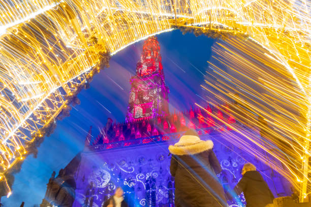 Blue star-shaped lanterns shining above a Christmas market stall in a nighttime setting.