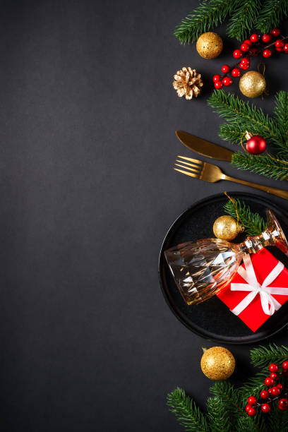 istock Christmas table setting with black plate, wine glass, cutlery and holidays decorations. 2184014000