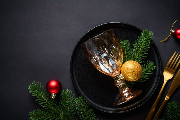 istock Christmas table setting with black plate, wine glass, cutlery and holidays decorations. 2184014023