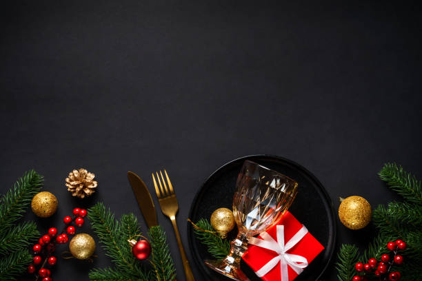 istock Christmas table setting with black plate, wine glass, cutlery and holidays decorations. 2184014111