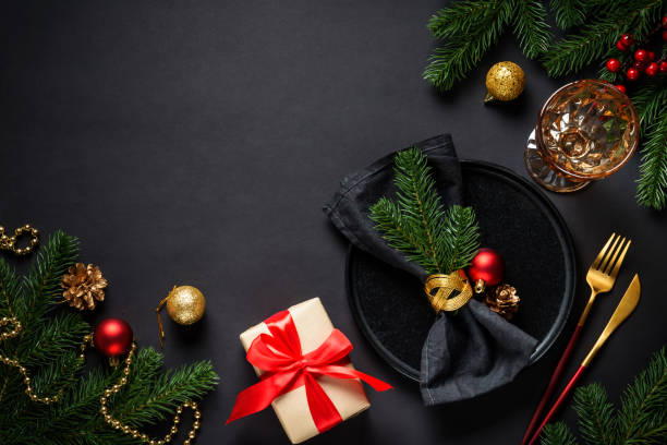 istock Christmas table setting with black plate, wine glass, cutlery and holidays decorations. 2184014179