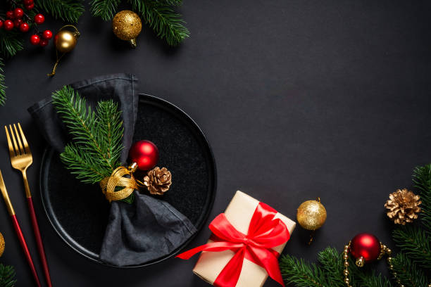 istock Christmas table setting with black plate, wine glass, cutlery and holidays decorations. 2184014890