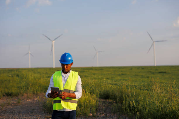 istock Young Engineer wearing uniform ,helmet hold document inspection work in wind turbine farms rotation to generate electricity energy 2184015865