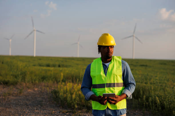 istock Young Engineer wearing uniform ,helmet hold document inspection work in wind turbine farms rotation to generate electricity energy. 2184016332