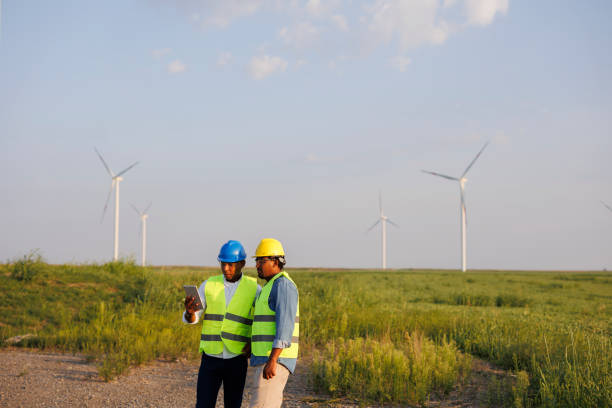 istock Two young Engineers wearing uniform ,helmet hold document inspection work in wind turbine farms rotation to generate electricity energy 2184016967