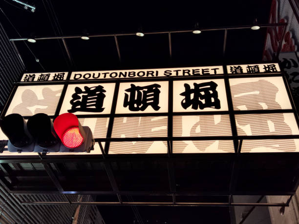 The eastern gate sign of Dotonbori street, a busy shopping and entertainment street in Dōtonbori, a district in Osaka, Japan. Historically a theater district, it is now a popular nightlife area characterized by its eccentric atmosphere and large illuminated signboards.