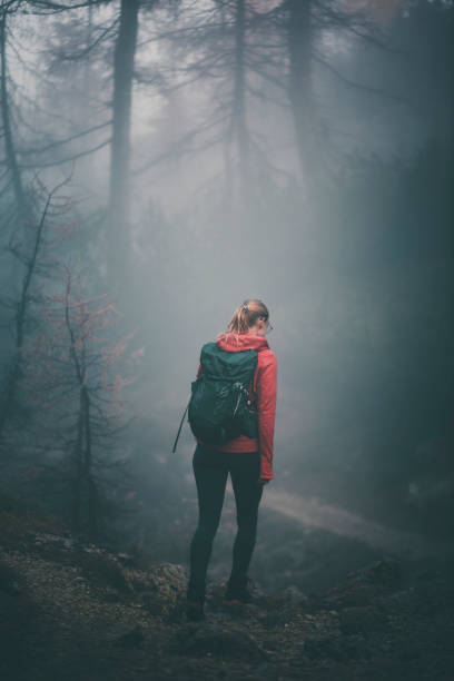 istock Young woman backpacks through misty forest 2184018980