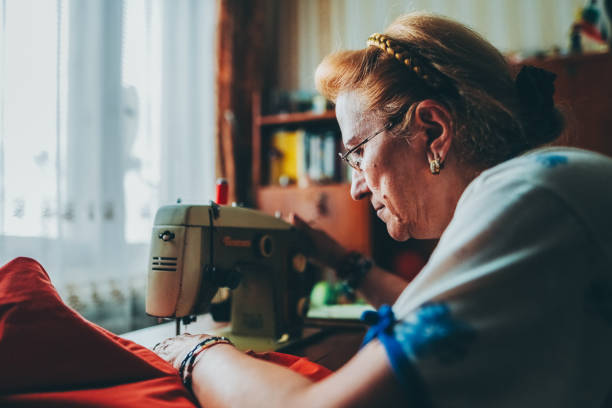 istock Retired woman at home working on sewing machine 2184020319